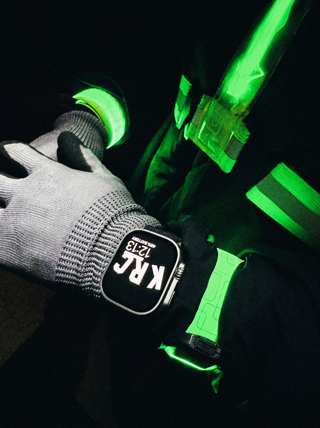 Ảnh cận cảnh cổ tay của một vận động viên chạy bộ đeo Apple Watch Ultra vào ban đêm.