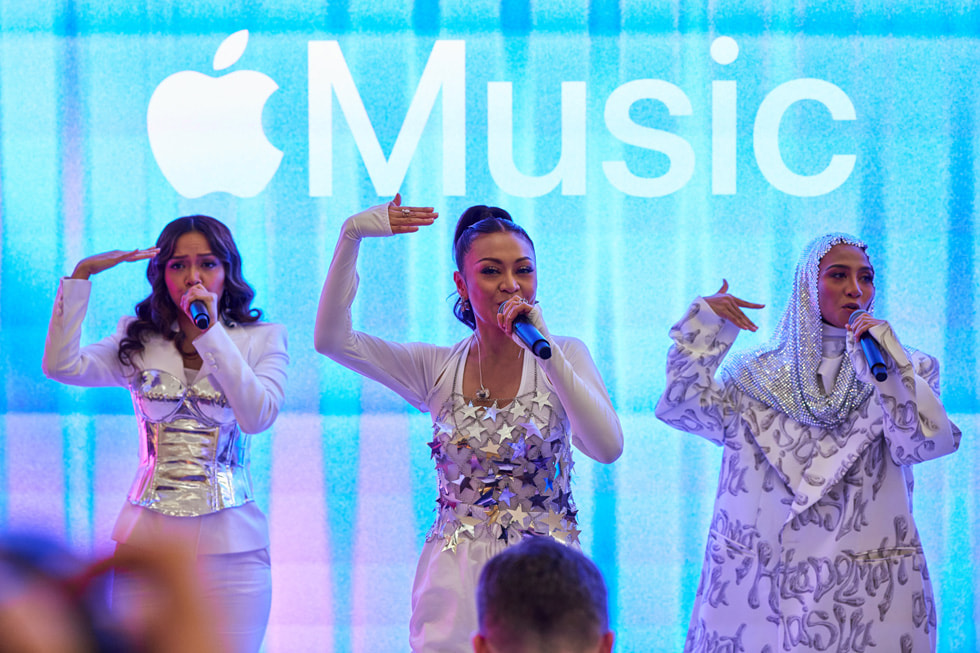 Nahaufnahme des Auftritts von De Fam mit dem Apple Music Logo auf dem Bildschirm hinter ihnen.
