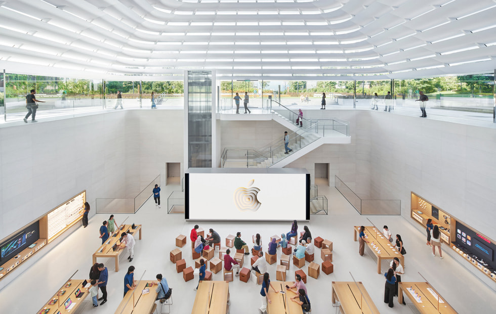 Plan dézoomé de l’intérieur du magasin qui met en évidence les étages de l’Apple Store ainsi que son escalier sculptural de quartz et de verre.
