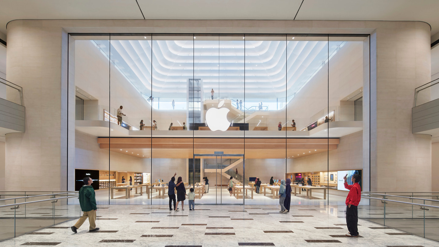 照片中，顧客站在 Apple The Exchange TRX 零售店內部入口前。