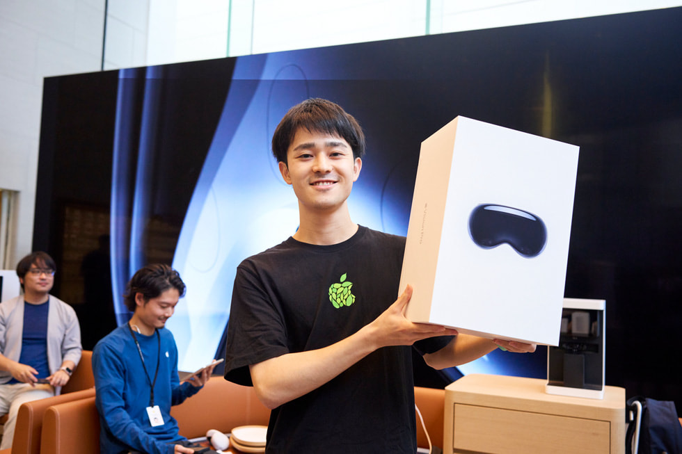 A customer holds up his Apple Vision Pro purchase inside Apple Omotesando.