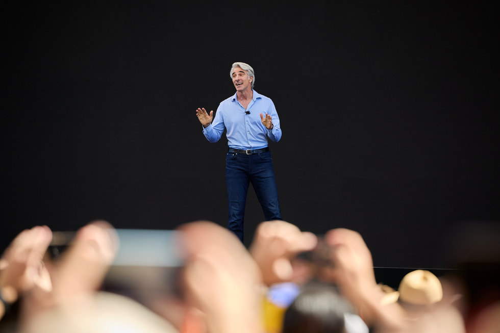 Craig Federighi de pie en un escenario en el Apple Park durante el día inaugural de la WWDC24.