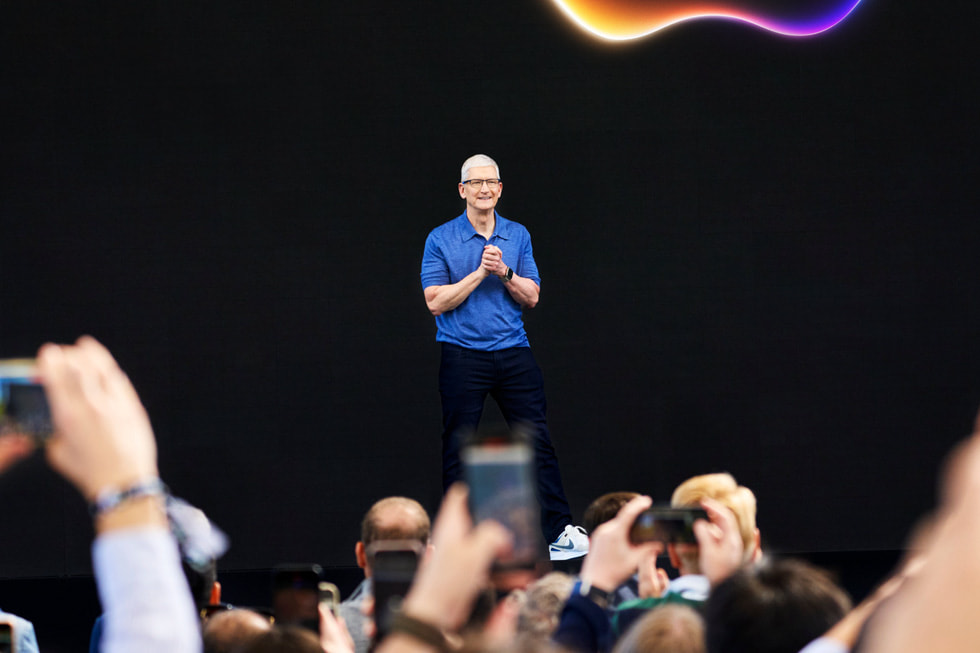 Tim Cook stands on a stage at at Apple Park on the opening day of WWDC24.