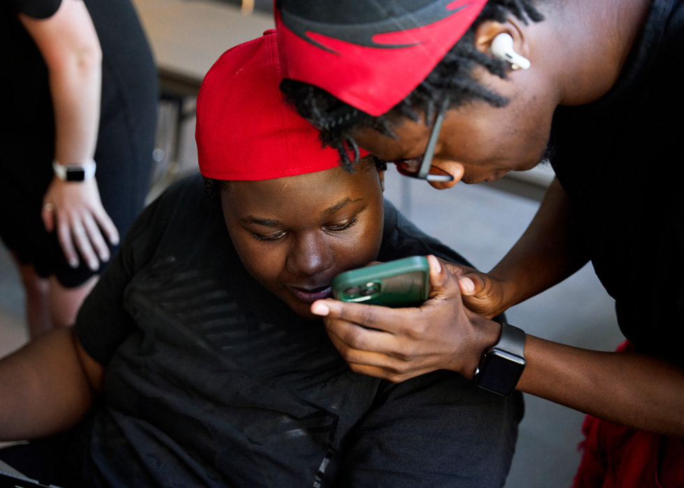 Glen-David Hardy-Covington y John Johnson miran la pantalla de un iPhone.