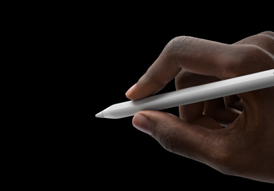 Une main tient un Apple Pencil Pro en position d’écriture. La pointe est orientée vers une interface affichant une nouvelle palette d’outils.