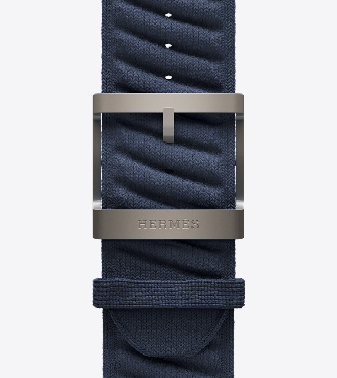 Close-up view of the textured knit En Mer strap in Bleu Nuit (navy blue) with a titanium buckle.