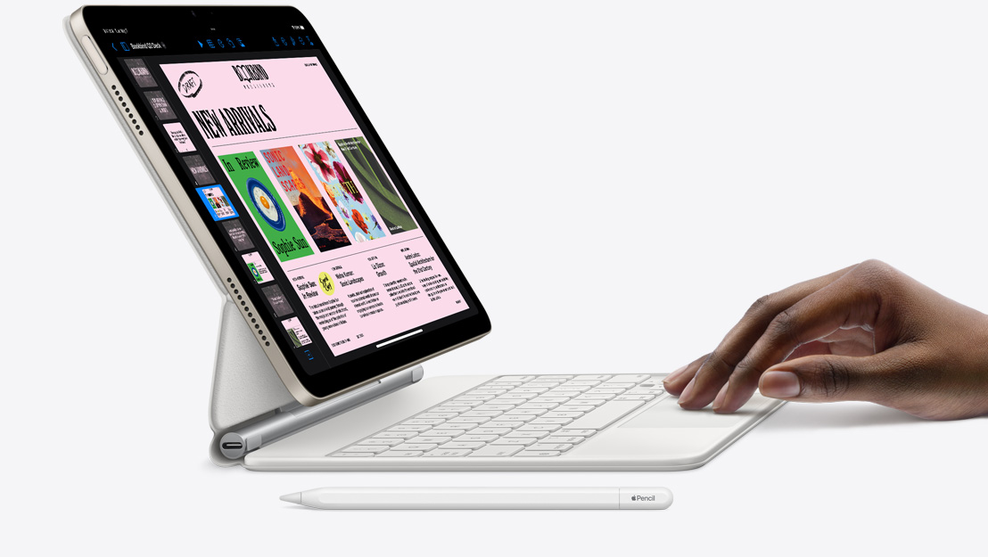 „iPad Air“ vaizdas iš šono, demonstruojantis programą „Keynote“, prijungta „Magic Keyboard“ su ranka ant manipuliatoriaus, o šalia „Apple Pencil“.